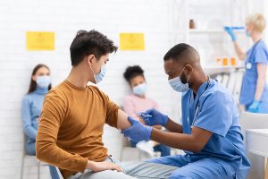 Young male worker getting corporate flu vaccination vouchers